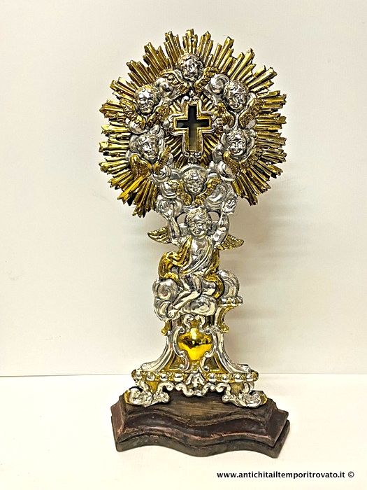 Reliquiario in lamiera sbalzata argentata e dorata con angeli - Vecchio porta reliquia a formaa di croce con raggiera con putti